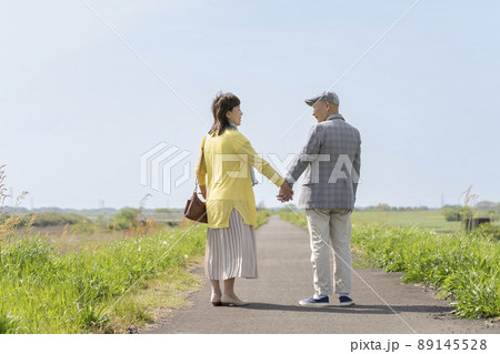 手を繋いで笑顔で見つめ合うシニア夫婦 89145528