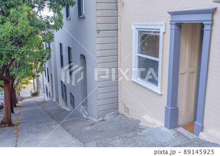 Steep sloped concrete side walk with steps in the middle in San Francisco, California Steep sloped concrete side walk with steps in the middle in San Francisco, California 89145925