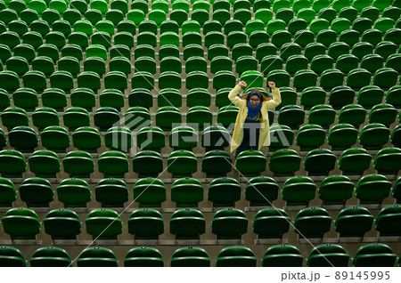 Caucasian woman cheers for a sports team at the stadium. The girl watches the match at the stadium alone. 89145995