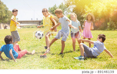 Company of glad children playing football on the playground Company of glad children playing football on the playground 89146139