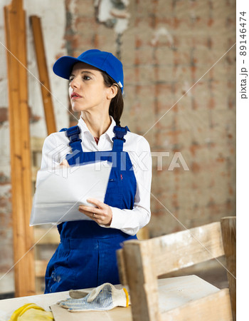 Female contractor taking notes while planning building renovation 89146474