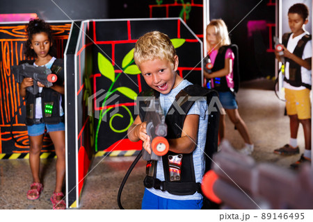Preteen boy with laser pistol playing on labyrinth Preteen boy with laser pistol playing on labyrinth 89146495