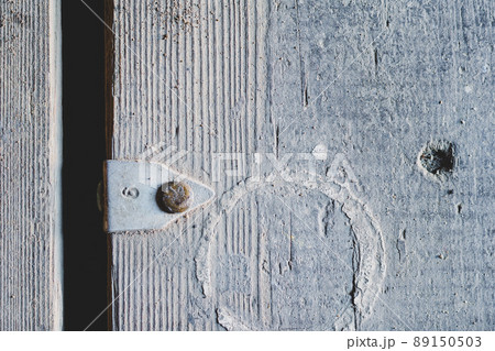 An old gray wooden surface with an aluminum tag nailed on it. The number nine is embossed on the tag. Dirty rough boards. The texture of the wood. Abstract multitasking background. An old gray wooden surface with an aluminum tag nailed on it. The number nine is embossed on the tag. Dirty rough boards. The texture of the wood. Abstract multitasking background. 89150503