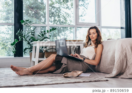 Businesswoman entrepreneur working on laptop from home office space sitting on floor 89150659