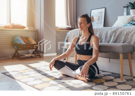 Woman sitting on floor at home and relaxing. 89150761