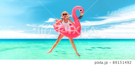 Vacation beach woman jumping of joy with pink flamingo pool float for summer holidays on ocean banner background. Fun travel excited girl for luxury Caribbean holiday panoramic Vacation beach woman jumping of joy with pink flamingo pool float for summer holidays on ocean banner background. Fun travel excited girl for luxury Caribbean holiday panoramic 89151492