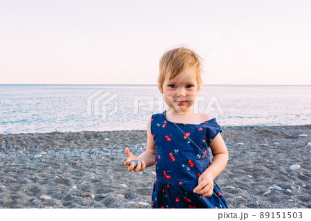 Little cute child girl playing on the seashore in summer Little cute child girl playing on the seashore in summer 89151503