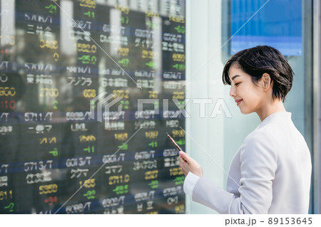 株価ボードを見る女性 89153645
