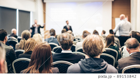 I have a question. Group of business people sitting in conference hall. Businessman raising his arm. Conference and Presentation. Business and Entrepreneurship 89153842