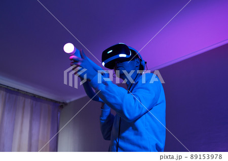 Man with virtual reality headset and joystic is playing game Man with virtual reality headset and joystic is playing game 89153978