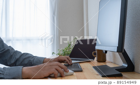 デスクの上のノートパソコンとモニター 89154949
