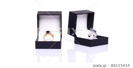 Gold ring with blue sapphire and diamond in dark blue jewel box. The platinum ring was placed next to it. Collection of natural gemstones accessories. Studio shot 89155434