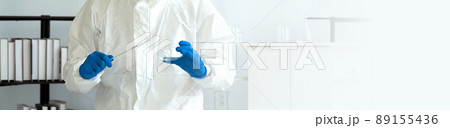 Epidemiological researchers in virus protective clothing holding inoculating needle and chemical petri dish. COVID-19 testing process in a laboratory. Epidemiological researchers in virus protective clothing holding inoculating needle and chemical petri dish. COVID-19 testing process in a laboratory. 89155436