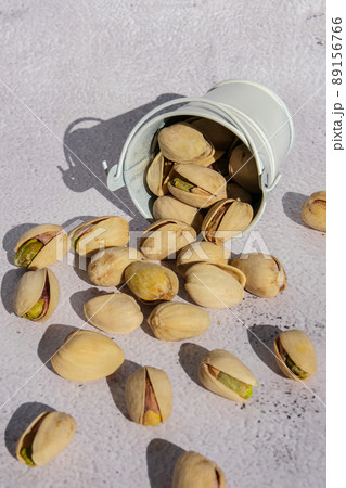 Pistachios in white bucket on concrete background. Healthy and dietary nutrition. Concept of nuts. Vegan protein omega vitamin food. 89156766