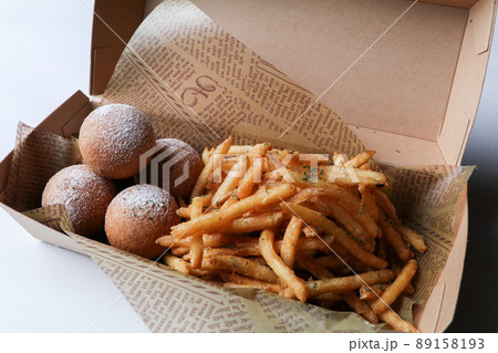 テイクアウト容器に入ったチーズボールとフライドポテト 89158193