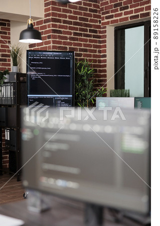 Interior of empty data center office with multiple computer screens showing programming line codes. Server room with modern brick wall interior and high quality hardware and software technology. Interior of empty data center office with multiple computer screens showing programming line codes. Server room with modern brick wall interior and high quality hardware and software technology. 89158226