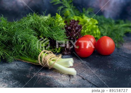 Fresh vegetables for salad. Tomatoes and lettuce, cucumbers with zucchini and cabbage with dill. Spring harvest, benefits and vitamins. On a dark background. Fresh vegetables for salad. Tomatoes and lettuce, cucumbers with zucchini and cabbage with dill. Spring harvest, benefits and vitamins. On a dark background. 89158727