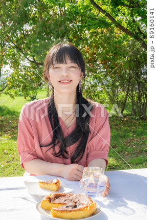 屋外で手作りチーズケーキを食べる女性 89160141