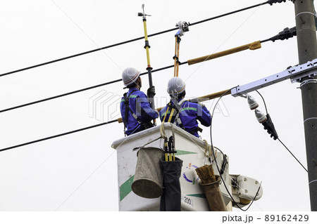 働く人＿空を背景に電柱に上って作業する人 89162429