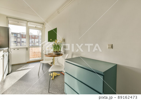 The interior of the kitchen with modern equipment and access to the balcony in a modern house 89162473