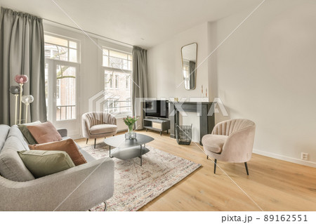 The interior of a spacious living room in an open design with a big sofa and carpet in a cozy house The interior of a spacious living room in an open design with a big sofa and carpet in a cozy house 89162551