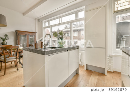 Kitchen with white furniture and marble countertops in a modern house Kitchen with white furniture and marble countertops in a modern house 89162879