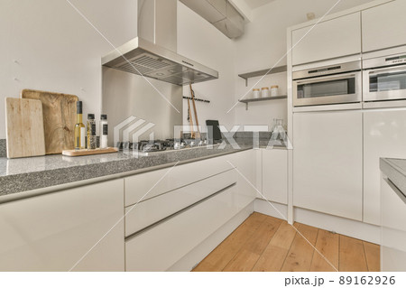 Kitchen with white furniture and marble countertops in a modern house 89162926