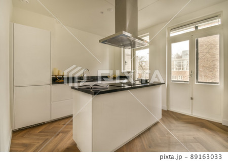 The interior of the kitchen in a modern style and white tones in a cozy apartment The interior of the kitchen in a modern style and white tones in a cozy apartment 89163033
