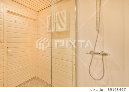 Glass shower cabin with wooden door walls and ceiling in a cozy house Glass shower cabin with wooden door walls and ceiling in a cozy house 89163447
