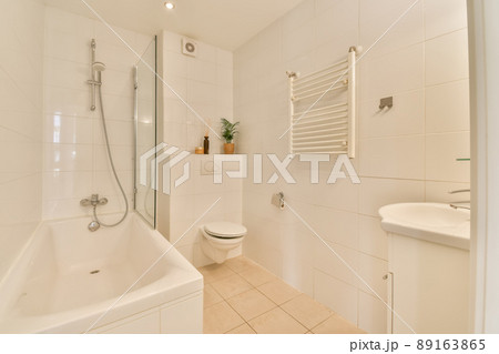 The interior of a cozy bathroom with a bathtub, shower, toilet and sink in a modern apartment 89163865