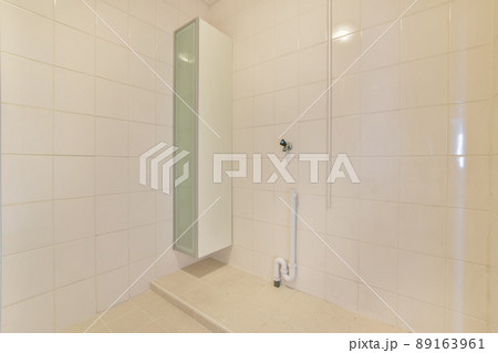 Bathroom interior with ceramic white tiles in the apartment of a cozy house Bathroom interior with ceramic white tiles in the apartment of a cozy house 89163961