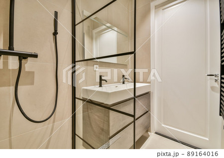 Shower stall and double sink in a modern bathroom in a minimalist style Shower stall and double sink in a modern bathroom in a minimalist style 89164016