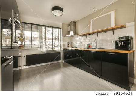 Spacious kitchen with dark furniture and wooden countertops in a modern house 89164023
