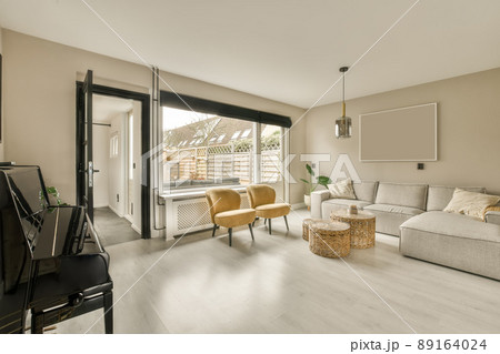 A spacious living room with a piano opposite the sofa in a cozy house A spacious living room with a piano opposite the sofa in a cozy house 89164024