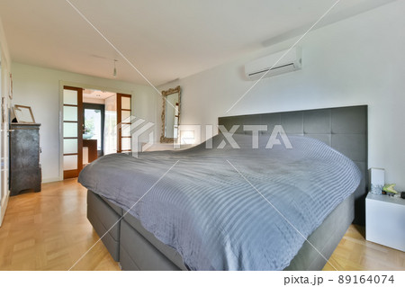 Spacious cozy bedroom with a large bed and a large mirror in a modern apartment 89164074