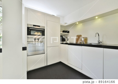 Modernized luxury and compact kitchen with white modern furniture and with all appliances Modernized luxury and compact kitchen with white modern furniture and with all appliances 89164166