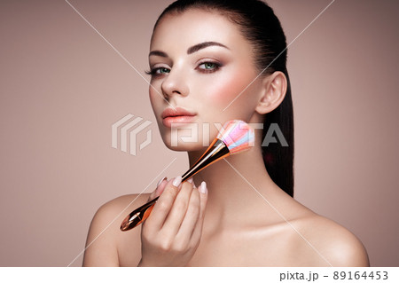 Beautiful Woman applies Skin Tone with Brush 89164453