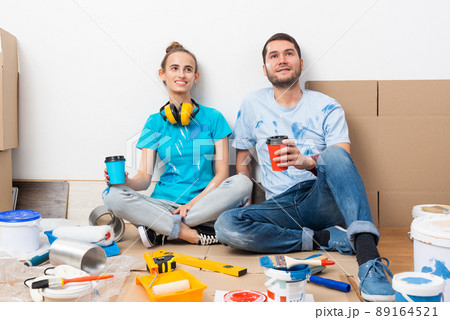 Happy boy and girl drinking coffee on floor. Happy boy and girl drinking coffee on floor. 89164521