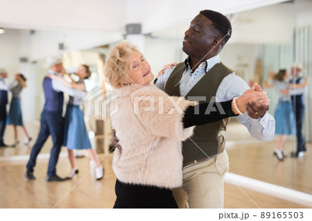 Elderly woman learning ballroom dancing in pair...の写真素材