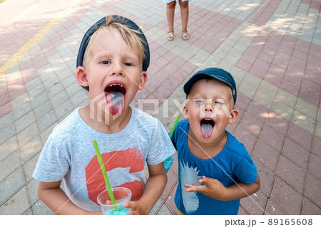 Preschooler and toddler with blue tongues from fruit ice 89165608