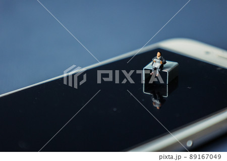 デジタル　スマートフォンで情報収集する人のイメージ（ミニチュア人形） 89167049