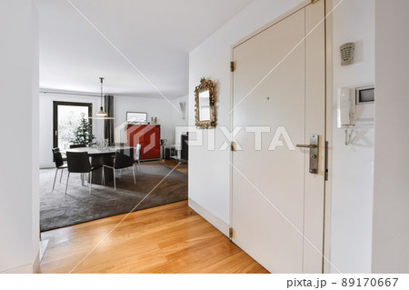 Lovely entrance part of the house with a small mirror and a dark rug Lovely entrance part of the house with a small mirror and a dark rug 89170667