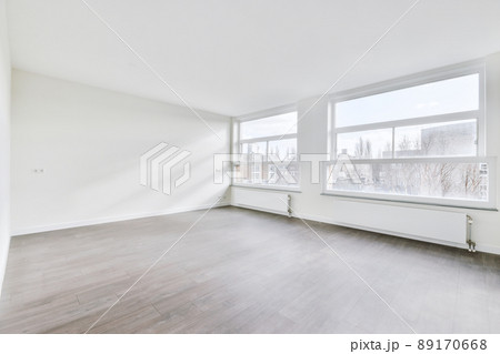 Small empty room with a parquet floor and a large window in a cozy house 89170668