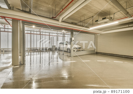 Underground parking with a car in a metal cage under a modern house Underground parking with a car in a metal cage under a modern house 89171100
