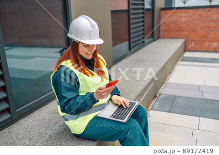 Hard working woman construction engineer standing on a construction site. Confident engineer talking on the phone and show casing work in progress Hard working woman construction engineer standing on a construction site. Confident engineer talking on the phone and show casing work in progress 89172419