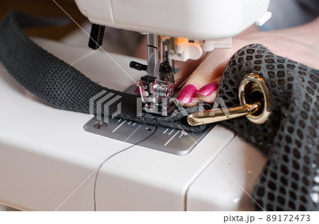 The woman at the sewing machine repair leather bag The woman at the sewing machine repair leather bag 89172473