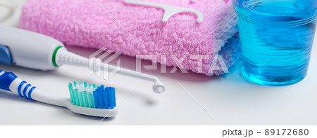 Dental hygiene. Toothbrush, mouthwash, pink towel, dental floss, oral irrigator. Horizontal photo. 89172680