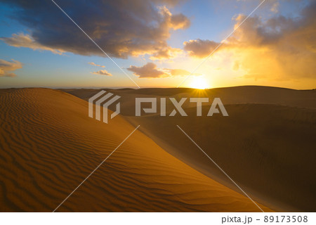 Sunset in the desert, sun and sun rays, blue sky and Beautiful clouds. Golden sand dunes in desert in Maspalomas, Gran Canaria at Canary islands, Spain 89173508