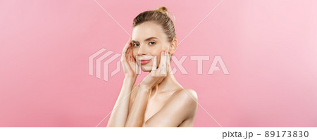 Beauty Spa Concept - Caucasian Woman with perfect face skin Portrait. Beautiful Brunette Spa Girl showing empty copy space. Isolated on pink studio background. Proposing a product. 89173830