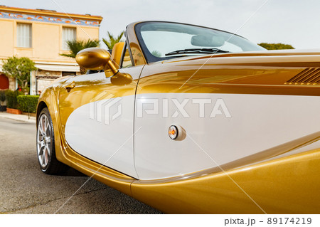 Close up view of exclusive vintage car is standing on narrow small streets, replica on the famous convertible car in French Riviera, Cap Ferrat, retro type, gold color, roadster, cote dazur 89174219